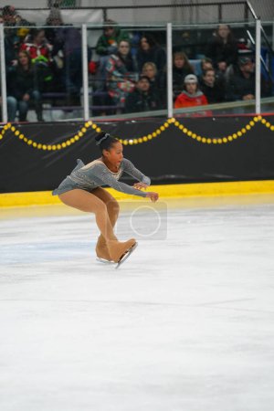 Téléchargez les photos : Mosinee, Wisconsin États-Unis - 26 février 2021 : Femme afro-américaine adulte dans une belle robe grise a participé à la compétition de patinage sur glace des jeux d'hiver de l'État du blaireau. - en image libre de droit