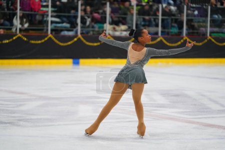 Photo for Mosinee, Wisconsin USA - February 26th, 2021: Adult african american female in a beautiful grey dress participated in badger state winter games ice skating competition. - Royalty Free Image