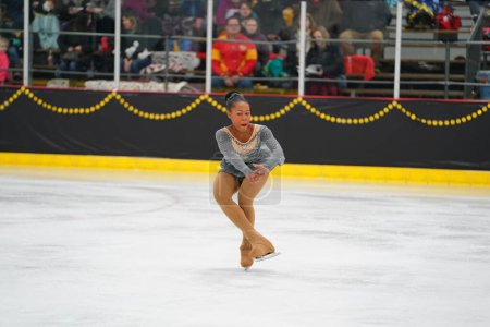Photo for Mosinee, Wisconsin USA - February 26th, 2021: Adult african american female in a beautiful grey dress participated in badger state winter games ice skating competition. - Royalty Free Image