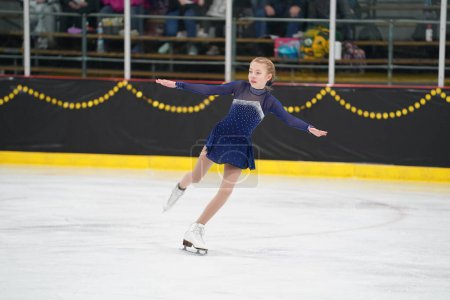 Téléchargez les photos : Mosinee, Wisconsin États-Unis - 26 février 2021 : Une jeune femme adulte dans une belle robe bleue a participé à la compétition de patinage sur glace des jeux d'hiver de l'État du blaireau - en image libre de droit