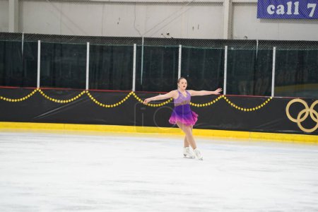 Photo for Mosinee, Wisconsin USA - February 26th, 2021: Young caucasian teenager female in a beautiful purple dress participated in badger state winter games ice skating competition - Royalty Free Image