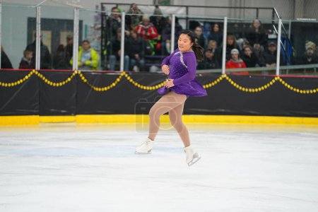 Photo for Mosinee, Wisconsin USA - February 26th, 2021: Asian adult female in a beautiful purple dress participated in badger state winter games ice skating competition - Royalty Free Image