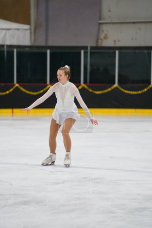 Photo for Mosinee, Wisconsin USA - February 26th, 2021: Young adult female in a beautiful white dress participated in badger state winter games ice skating competition. - Royalty Free Image