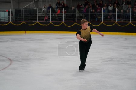 Foto de Mosinee, Wisconsin, Estados Unidos - 26 de febrero de 2021: Joven adolescente varón participó en la competencia de patinaje sobre hielo de los juegos de invierno de Badger State - Imagen libre de derechos