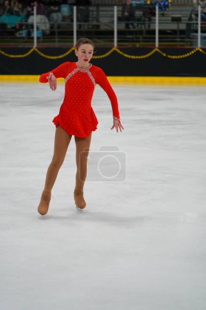 Téléchargez les photos : Mosinee, Wisconsin États-Unis - 26 février 2021 : Jeune femme dans une belle robe rouge a participé à la compétition de patinage sur glace des jeux d'hiver de l'État du blaireau - en image libre de droit
