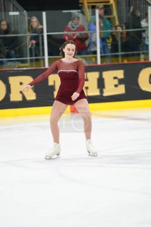 Photo for Mosinee, Wisconsin USA - February 26th, 2021: Young female in a beautiful red dress participated in badger state winter games ice skating competition - Royalty Free Image