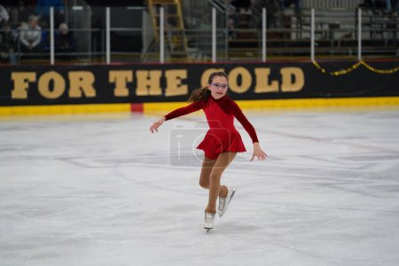 Photo for Mosinee, Wisconsin USA - February 26th, 2021: Adult female in a beautiful red dress participated in badger state winter games ice skating competition - Royalty Free Image