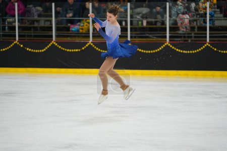 Foto de Mosinee, Wisconsin, EE.UU. - 26 de febrero de 2021: Mujer adulta con un hermoso vestido azul participó en la competencia de patinaje sobre hielo de los juegos de invierno de Badger State. - Imagen libre de derechos