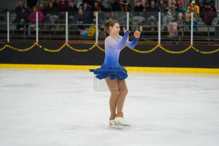 Photo for Mosinee, Wisconsin USA - February 26th, 2021: Adult female in a beautiful blue dress participated in badger state winter games ice skating competition - Royalty Free Image