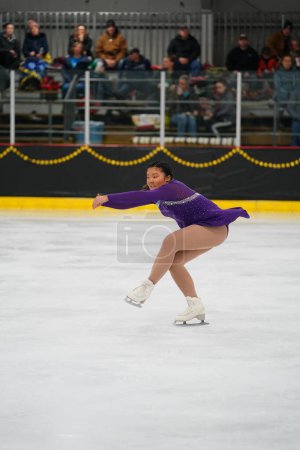 Téléchargez les photos : Mosinee, Wisconsin États-Unis - février 26th, 2021 : Femme adulte asiatique dans une belle robe pourpre a participé à la compétition de patinage sur glace des jeux d'hiver de l'État du blaireau - en image libre de droit
