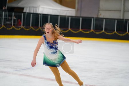 Foto de Mosinee, Wisconsin, EE.UU. - 26 de febrero de 2021: Mujer adulta con un hermoso vestido blanco participó en la competencia de patinaje sobre hielo de los juegos de invierno de Badger State. - Imagen libre de derechos