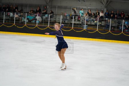 Téléchargez les photos : Mosinee, Wisconsin États-Unis - 26 février 2021 : Une jeune femme adulte dans une belle robe violette a participé à la compétition de patinage sur glace des jeux d'hiver de l'État du blaireau - en image libre de droit