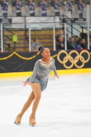 Téléchargez les photos : Mosinee, Wisconsin États-Unis - 26 février 2021 : Femme afro-américaine adulte dans une belle robe grise a participé à la compétition de patinage sur glace des jeux d'hiver de l'État du blaireau. - en image libre de droit