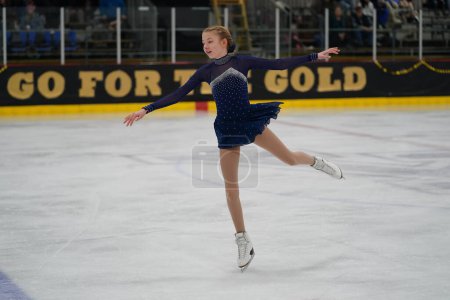 Photo for Mosinee, Wisconsin USA - February 26th, 2021: Young adult female in a beautiful purple dress participated in badger state winter games ice skating competition - Royalty Free Image