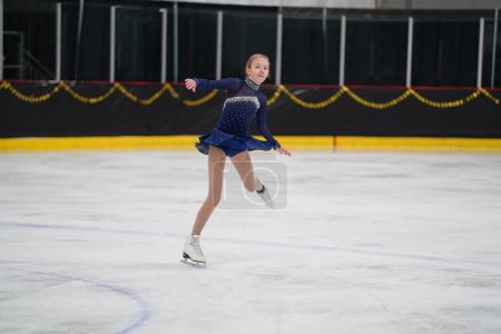 Téléchargez les photos : Mosinee, Wisconsin États-Unis - 26 février 2021 : Une jeune femme adulte dans une belle robe violette a participé à la compétition de patinage sur glace des jeux d'hiver de l'État du blaireau - en image libre de droit