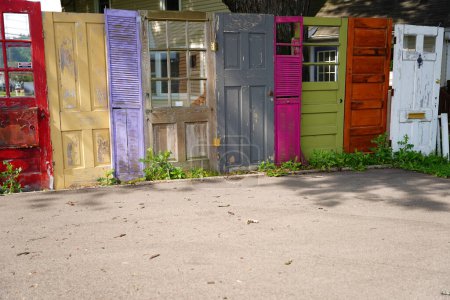 Téléchargez les photos : Groupe de portes colorées aléatoires utilisées comme clôture de cour dans Columbus, Wisconsin. - en image libre de droit