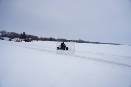 Photo for Fond du Lac, Wisconsin / USA - March 9th, 2019: People enjoying themselves on the frozen Winnebago Lake driving around ATVs and Quad bikes on the ice - Royalty Free Image