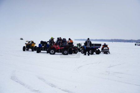 Photo for Fond du Lac, Wisconsin / USA - March 9th, 2019: People enjoying themselves on the frozen Winnebago Lake driving around ATVs and Quad bikes on the ice - Royalty Free Image
