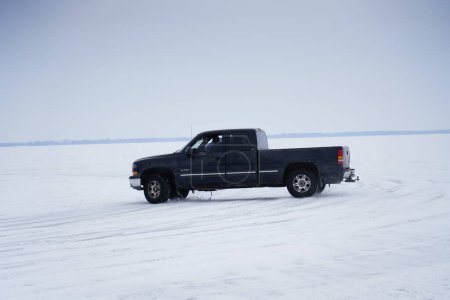 Foto de Fond du Lac, Wisconsin / Estados Unidos - 9 de marzo de 2019: Gente disfrutando en el lago Winnebago congelado conduciendo alrededor de vehículos en el hielo - Imagen libre de derechos