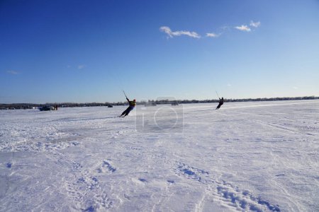 Foto de Fond du Lac, Wisconsin, EE. UU. - 8 de febrero de 2019: Los lugareños de la comunidad de aficionados du lac disfrutaron del kite de hielo de invierno haciendo windsurf en el lago congelado de winnebago. - Imagen libre de derechos
