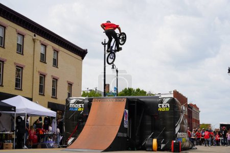 Foto de Racine, Wisconsin, EE.UU. - 16 de septiembre de 2023: Bicicletas dobles en bicicletas BMX haciendo acrobacias en rampas de media tubería para una multitud de personas en las calles de Racine, Wisconsin - Imagen libre de derechos