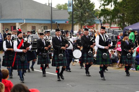 Photo for La Crosse, Wisconsin USA - October 5th, 2022: La Crosse bagpipes and drums Scottish band marched in Oktoberfest parade. - Royalty Free Image