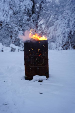 Photo for Burning trash barrel sits outside during the cold winter. - Royalty Free Image