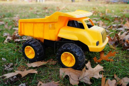 Foto de Camión volquete amarillo juguete se sienta fuera - Imagen libre de derechos