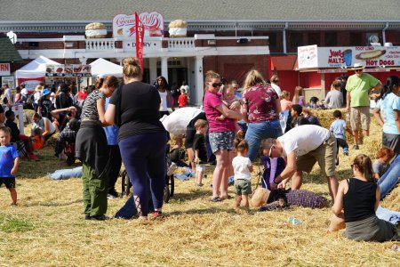 Foto de Milwaukee, Wisconsin, EE.UU. - 30 de septiembre de 2023: Miembros de la familia se reúnen en el festival Wisconsin State Fair for Harvest Fair para crear espantapájaros a partir del heno. - Imagen libre de derechos