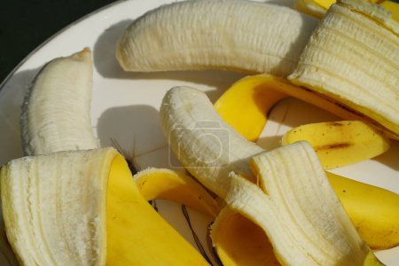 Foto de Banana amarilla pelada se sienta en un plato listo para comer. - Imagen libre de derechos