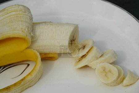 Photo for Peeled and sliced yellow Banana sits on a plate ready to be eaten. - Royalty Free Image