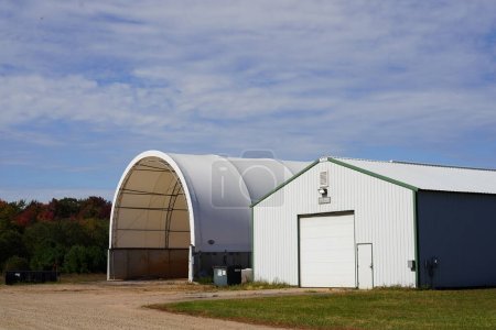 Foto de Nueva Lisboa, Wisconsin, EE.UU. - 1 de octubre de 2022: Grandes edificios de almacenamiento de material blanco en el campo. - Imagen libre de derechos
