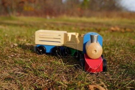 Photo for Children's wooden toy train sits outside. - Royalty Free Image