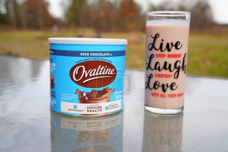 Photo for New Lisbon, Wisconsin USA - November 8th, 2022: A canister of Nestl Ovaltine rich chocolate milk mix and a glass of milk sit outside. - Royalty Free Image