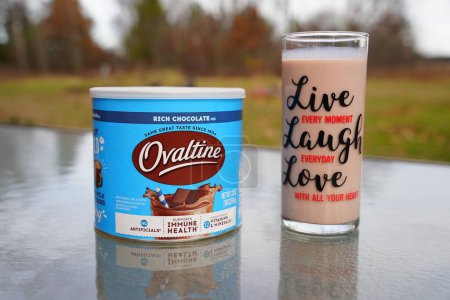 Téléchargez les photos : New Lisbon, Wisconsin États-Unis - 8 novembre 2022 : Une boîte de Nestl Ovaltine riche mélange de chocolat au lait et un verre de lait assis à l'extérieur. - en image libre de droit