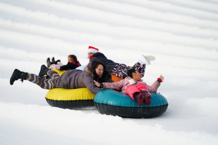 Foto de Kewaskum, Wisconsin / Estados Unidos - 24 de diciembre de 2019: Muchos miembros de la familia salieron a disfrutar de los tubos de nieve el día antes de Navidad en el Sunburst Winter Sports Park para el evento de Santa Slalom. - Imagen libre de derechos