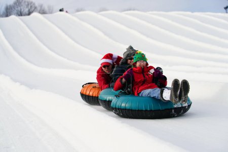 Photo for Kewaskum, Wisconsin / USA - December 24th, 2019: Many family members came out to enjoy themselves snow tubing on the day before Christmas at Sunburst Winter Sports Park for Santa Slalom event. - Royalty Free Image