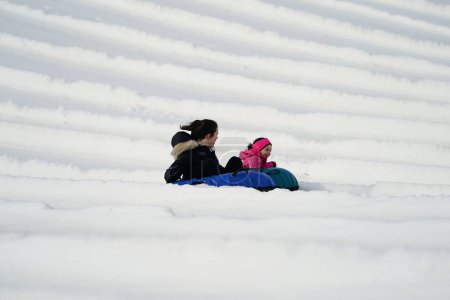 Photo for Kewaskum, Wisconsin / USA - December 24th, 2019: Many family members came out to enjoy themselves snow tubing on the day before Christmas at Sunburst Winter Sports Park for Santa Slalom event. - Royalty Free Image