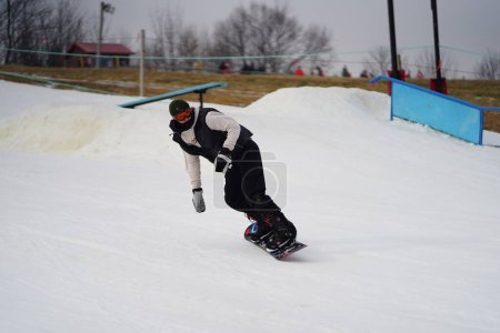 Foto de Kewaskum, Wisconsin / Estados Unidos - 24 de diciembre de 2019: Miembros de la comunidad salieron a disfrutar del snowboard el día antes de Navidad en el Sunburst Winter Sports Park para el evento de Santa Slalom. - Imagen libre de derechos