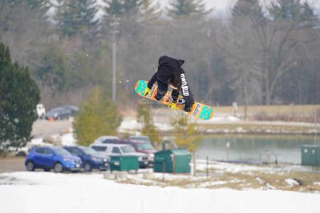 Foto de Kewaskum, Wisconsin / Estados Unidos - 24 de diciembre de 2019: Miembros de la comunidad salieron a disfrutar del snowboard el día antes de Navidad en el Sunburst Winter Sports Park para el evento de Santa Slalom. - Imagen libre de derechos