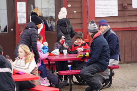 Téléchargez les photos : Kewaskum, Wisconsin / États-Unis - 24 décembre 2019 : De nombreux membres de la famille sont venus profiter de vacances la veille de Noël au Sunburst Winter Sports Park pour l'événement Santa Slalom. - en image libre de droit