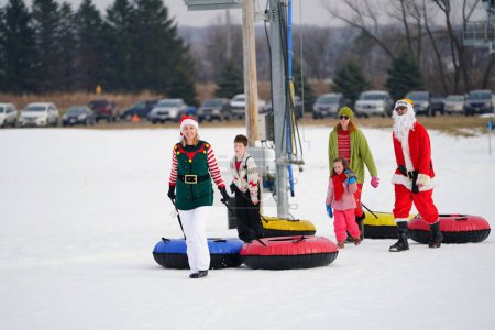 Téléchargez les photos : Kewaskum, Wisconsin / États-Unis - 24 décembre 2019 : De nombreux membres de la famille sont sortis pour s'amuser dans un bain de neige la veille de Noël au Sunburst Winter Sports Park pour le Santa Slalom. - en image libre de droit