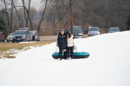 Téléchargez les photos : Kewaskum, Wisconsin / États-Unis - 24 décembre 2019 : De nombreux membres de la famille sont sortis pour s'amuser dans un bain de neige la veille de Noël au Sunburst Winter Sports Park pour le Santa Slalom. - en image libre de droit