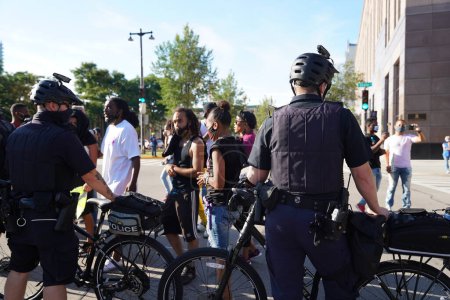 Foto de Milwaukee, Wisconsin / Estados Unidos - 20 de agosto de 2020: Oficiales de policía de Milwaukee observan cómo las vidas de negros importan a manifestantes de jacob blake marchan por las calles. - Imagen libre de derechos