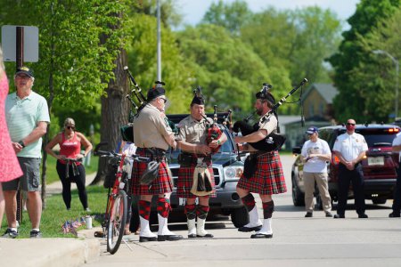 Foto de Oconomowoc, Wisconsin / Estados Unidos - 25 de mayo de 2020: Jugadores veteranos de gaitas de la VFW jugando una gracia increíble mientras la comunidad recordaba a los soldados caídos que han luchado por nuestras libertades. - Imagen libre de derechos