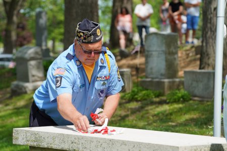 Téléchargez les photos : Oconomowoc, Wisconsin / États-Unis - 25 mai 2020 : Des vétérans et des officiers supérieurs posent des rubans commémoratifs de soldats tombés au combat sur la tombe d'un soldat inconnu au cimetière de la belle pour honorer le jour du Souvenir. - en image libre de droit