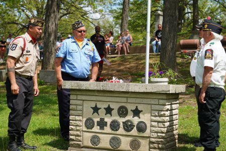 Foto de Oconomowoc, Wisconsin / Estados Unidos - 25 de mayo de 2020: Veteranos y oficiales de alto rango colocan cintas de recuerdo de soldados caídos en la tumba de soldados desconocidos en el cementerio de la belle para honrar el día conmemorativo. - Imagen libre de derechos