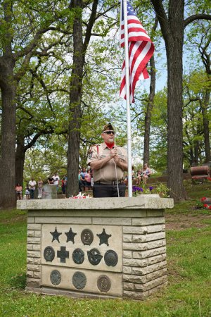 Photo for Oconomowoc, Wisconsin / USA - May 25th, 2020: Veterans and senior officers placing remembrance ribbons of fallen soldiers on the unknown soldier grave at la belle cemetery for honoring memorial day. - Royalty Free Image