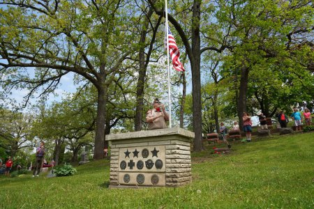 Foto de Oconomowoc, Wisconsin / Estados Unidos - 25 de mayo de 2020: Veteranos y oficiales de alto rango colocan cintas de recuerdo de soldados caídos en la tumba de soldados desconocidos en el cementerio de la belle para honrar el día conmemorativo. - Imagen libre de derechos