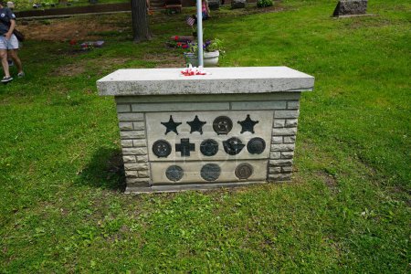 Foto de Oconomowoc, Wisconsin / Estados Unidos - 25 de mayo de 2020: Cintas conmemorativas de oficiales militares caídos colocadas en la tumba de un soldado desconocido en el cementerio de la belle en recuerdo de su servicio en el día de la memoria. - Imagen libre de derechos